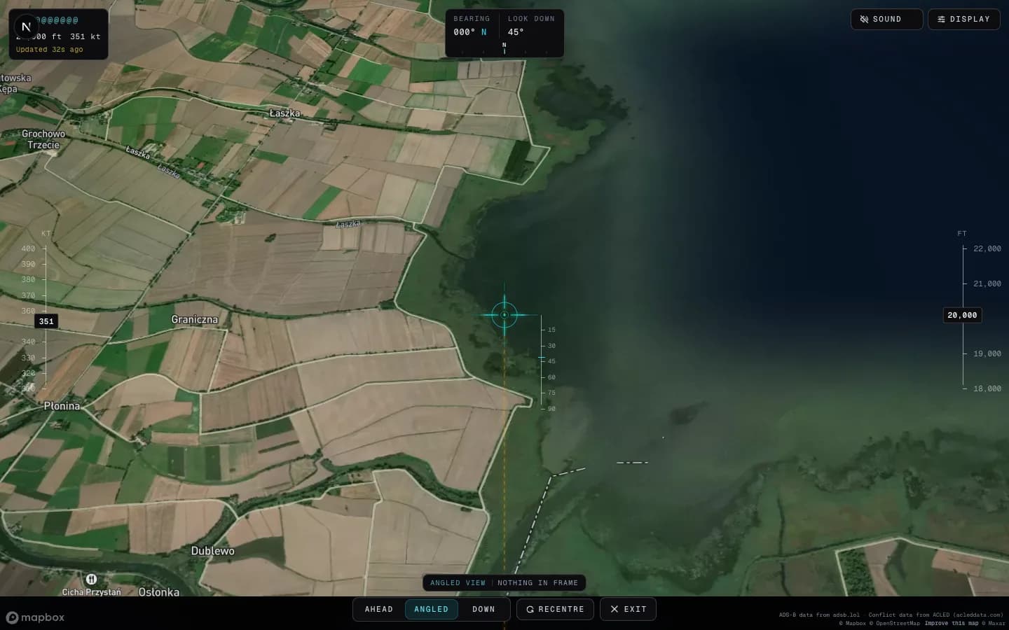 Looking out from a maritime patrol aircraft at 20,000 ft: the centre-line reticle over the Vistula Lagoon coast, a look-down scale beside it, speed and altitude tapes down each edge, and the aim readout in the corner.